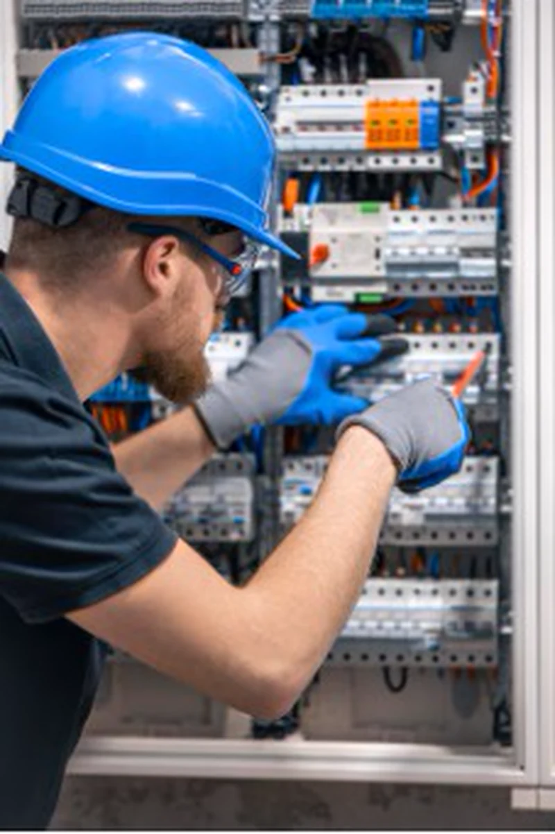 Electrical-panel wiring at PTC Loma Campana by a technician wearing a blue hard hat